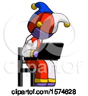 Purple Jester Joker Man Using Laptop Computer While Sitting In Chair Angled Right
