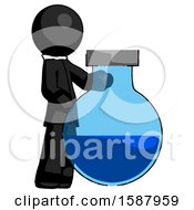 Black Clergy Man Standing Beside Large Round Flask Or Beaker