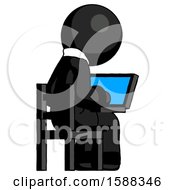 Black Clergy Man Using Laptop Computer While Sitting In Chair View From Back