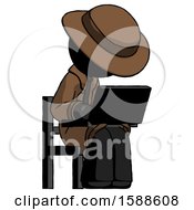 Black Detective Man Using Laptop Computer While Sitting In Chair Angled Right