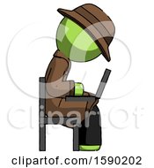 Green Detective Man Using Laptop Computer While Sitting In Chair View From Side