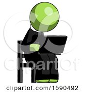 Green Clergy Man Using Laptop Computer While Sitting In Chair Angled Right