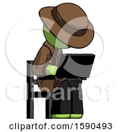 Green Detective Man Using Laptop Computer While Sitting In Chair Angled Right