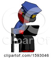 Red Police Man Using Laptop Computer While Sitting In Chair Angled Right
