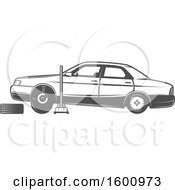 Poster, Art Print Of Car Lifted On A Jack With A Tire Being Replaced