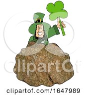 Cartoon St Patricks Day Leprechaun Holding Up A Shamrock Behind A Rock