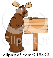 Poster, Art Print Of Big Moose Standing Next To And Pointing At A Blank Wood Sign