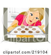 Dirty Blond Woman Pulling Chocolate Chip Cookies Out Of An Oven