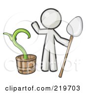 White Man Holding A Shovel By A Potted Plant