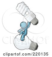 Denim Blue Man Design Mascot Sitting On An Old Light Bulb And Holding Up A New Energy Efficient Bulb