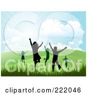 Silhouetted Happy Children Running And Jumping In A Hilly Summer Or Spring Landscape