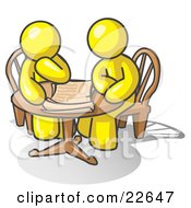 Two Yellow Businessmen Sitting At A Table Discussing Papers