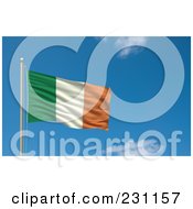 Flag Of Ireland Waving On A Pole Against A Blue Sky