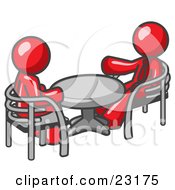 Two Red Business Men Sitting Across From Eachother At A Table During A Meeting