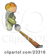 Olive Green Man Contractor Wearing A Hardhat Kneeling And Measuring