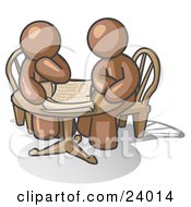 Two Brown Businessmen Sitting At A Table Discussing Papers