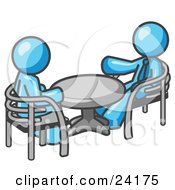 Two Light Blue Business Men Sitting Across From Eachother At A Table During A Meeting