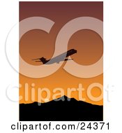 Silhouetted Commercial Airliner Flying Away During Departure Against An Orange Sunset Sky With Mountains