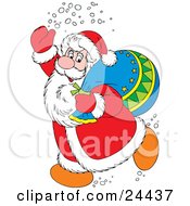 Santa Claus In A Red And White Suit Waving And Treading Snow Carrying A Toy Sack Over His Shoulder