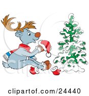 Cute Gray Reindeer With Brown Antlers Wearing A Scarf And Holding A Santa Hat While Sitting In Front Of A Snow Flocked Tree