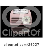 Vintage Pink Radio With A Station Tuner On A Reflective Black Surface