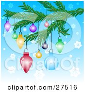 Colorful Christmas Tree Ornaments Hanging From A Tree Branch Over A Blue Snowflake Background