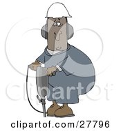 Black Man In A Hardhat And Ear Muffs Operating A Jackhammer At A Construction Site