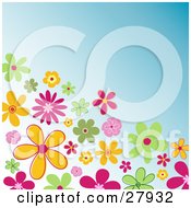 Corner Of Colorful Green Orange And Pink Flowers Over A Blue Background