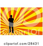 Poster, Art Print Of Black Silhouetted Man Standing Over A Bursting Yellow And Orange Background