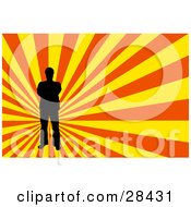 Clipart Illustration Of A Black Silhouetted Man Standing Over A Bursting Yellow And Orange Background