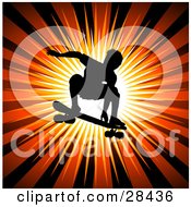 Silhouetted Male Skateboarder Leaping Through The Air On His Board Over A Bursting Orange Background