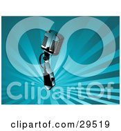 Clipart Illustration Of A Chrome Retro Microphone Over A Background Of Rays Of Blue Light by KJ Pargeter