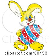 Clipart Illustration Of A Friendly Yellow Easter Bunny Smiling And Holding A Large Colorful Floral Patterned Easter Egg In Front Of Him