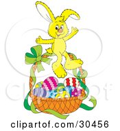 Poster, Art Print Of Cute Yellow Bunny Rabbit Sitting On Top Of A Basket Of Easter Eggs With A Green Ribbon On The Handle