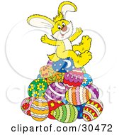Happy Yellow Easter Bunny Sitting On Top Of A Pile Of Decorated Easter Eggs by Alex Bannykh