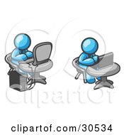 Two Light Blue Men Employees Working On Computers In An Office One Using A Desktop The Other Using A Laptop