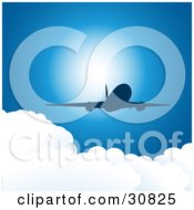 Silhouetted Commercial Airplane Flying Above Puffy White Clouds In A Blue Sky With Sunlight