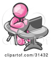 Clipart Illustration Of A Pink Man Working On A Laptop Computer On A Table