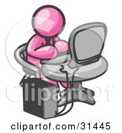 Clipart Illustration Of A Pink Man Working On A Desktop Computer On A Table