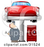 White Male Mechanic Holding A Wrench And Working On A Red Classic Car Up On A Lift In A Garage
