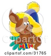 Poster, Art Print Of Cute Brown Puppy Resting On Gloves With A Treat Under A Blue And Yellow Hat