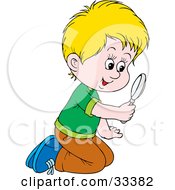 Curious Blond Boy Kneeling On The Ground And Peering Through A Magnifying Glass