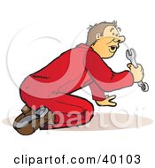 Poster, Art Print Of Busy Male Mechanic In Red Coveralls Kneeling And Using A Wrench