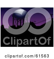 Royalty Free RF Clipart Illustration Of Light Shining On A Water Tower Over Silhouetted Roof Tops Against A Purple Sky