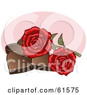 Two Red Roses Resting On Chocolate Hearts