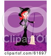 Pretty Red Haired Witch Standing With A Broom At The Edge Of A Cemetery