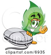 Clipart Picture Of A Leaf Mascot Cartoon Character Standing By A Computer Mouse by Toons4Biz