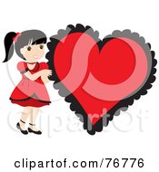 Black Haired Caucasian Girl In A Red Dress Standing By A Big Red Heart