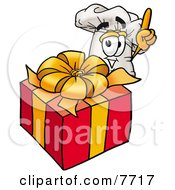 Chefs Hat Mascot Cartoon Character Standing By A Christmas Present