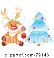 Cute Rudolph The Red Nosed Reindeer Hanging Baubles On A Blue Icy Christmas Tree